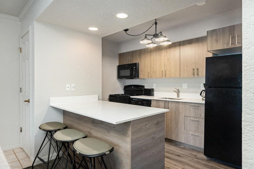 a kitchen with a white counter top and wooden cabinets
