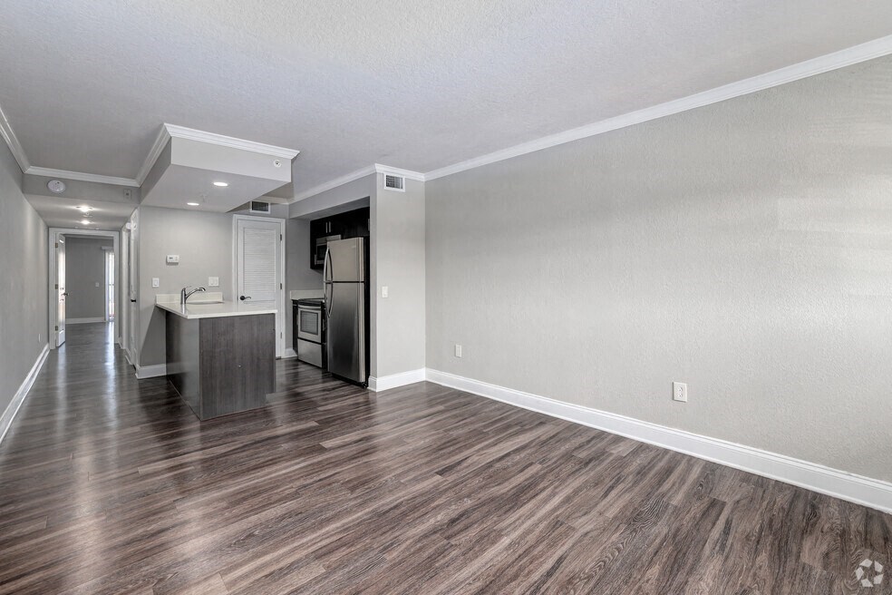 an empty living room and kitchen with wood flooring
