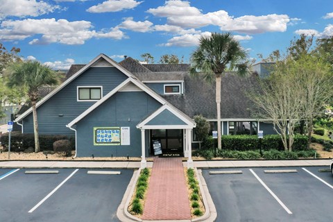 a blue house with a parking lot and palm trees at AVIA Lofts on Liberty Ridge Apartments, Jacksonville, FL