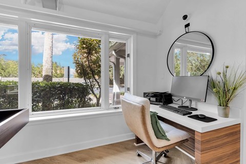 a home office with a large window and a desk with a computer at AVIA Lofts on Liberty Ridge Apartments, Jacksonville, FL, 32256
