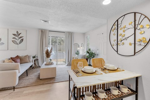 a living room and dining room with a table and chairs at AVIA Lofts on Liberty Ridge Apartments, Jacksonville 32256