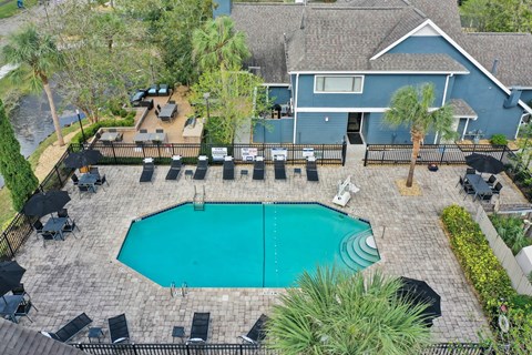 an aerial view of a swimming pool with a house in the background at AVIA Lofts on Liberty Ridge Apartments, Florida