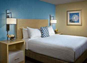 a hotel room with a bed and two night stands with lamps