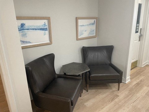 a living room with two black chairs and a table