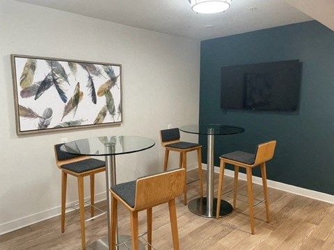 a living room with three tables and a television