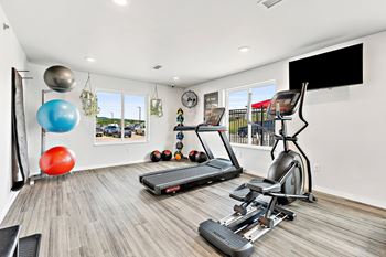 a workout room with treadmills and a flat screen tv at Red Rock Apartments, Rapid City, South Dakota