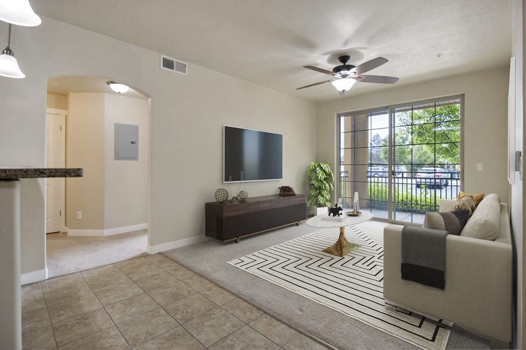 a living room with a large window and a ceiling fan at Siena Villas Apartments, Orem