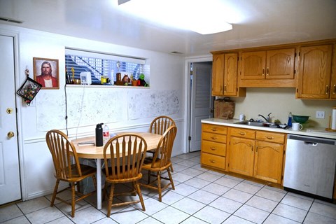 A kitchen with a table and chairs.