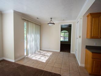 an empty living room with a tile floor and a door way
