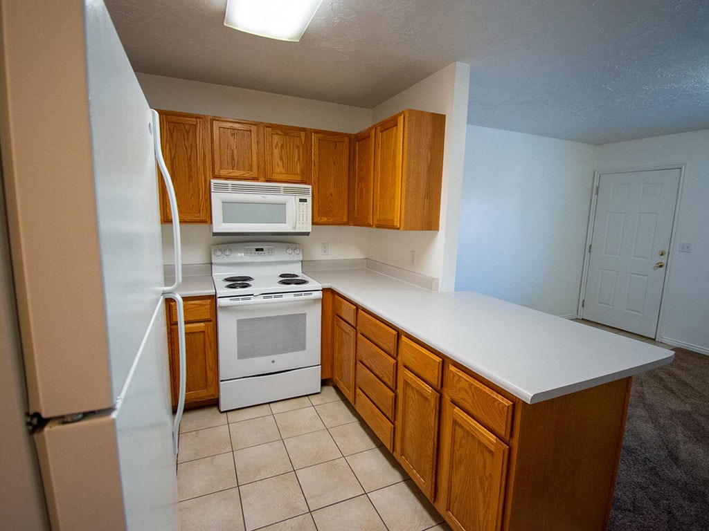 a kitchen with white appliances and wooden cabinets
