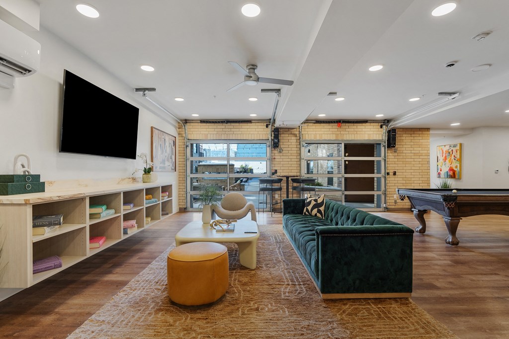 a living room with a green couch and a pool table at The Revival, Utah, 84101