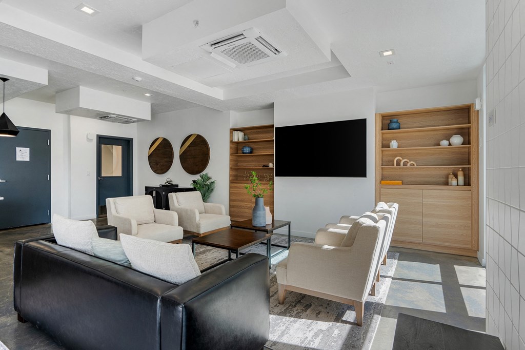 a living room with a couch and chairs and a television at The Flats at Riverwoods, Provo, Utah