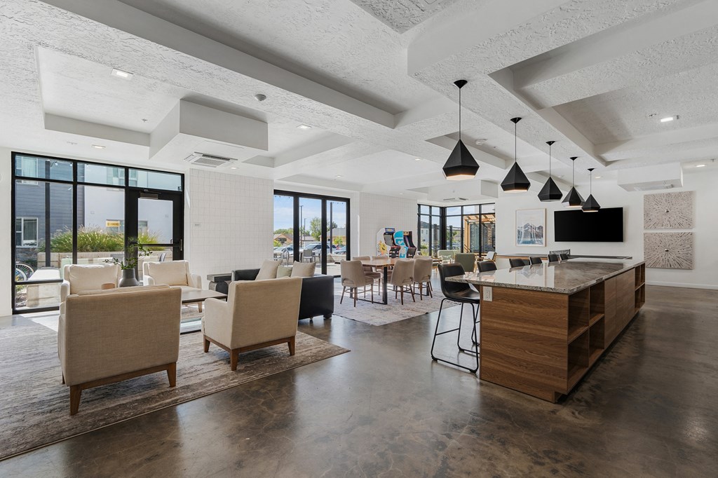 a clubhouse with a bar and chairs and a living room with a television at The Flats at Riverwoods, Provo