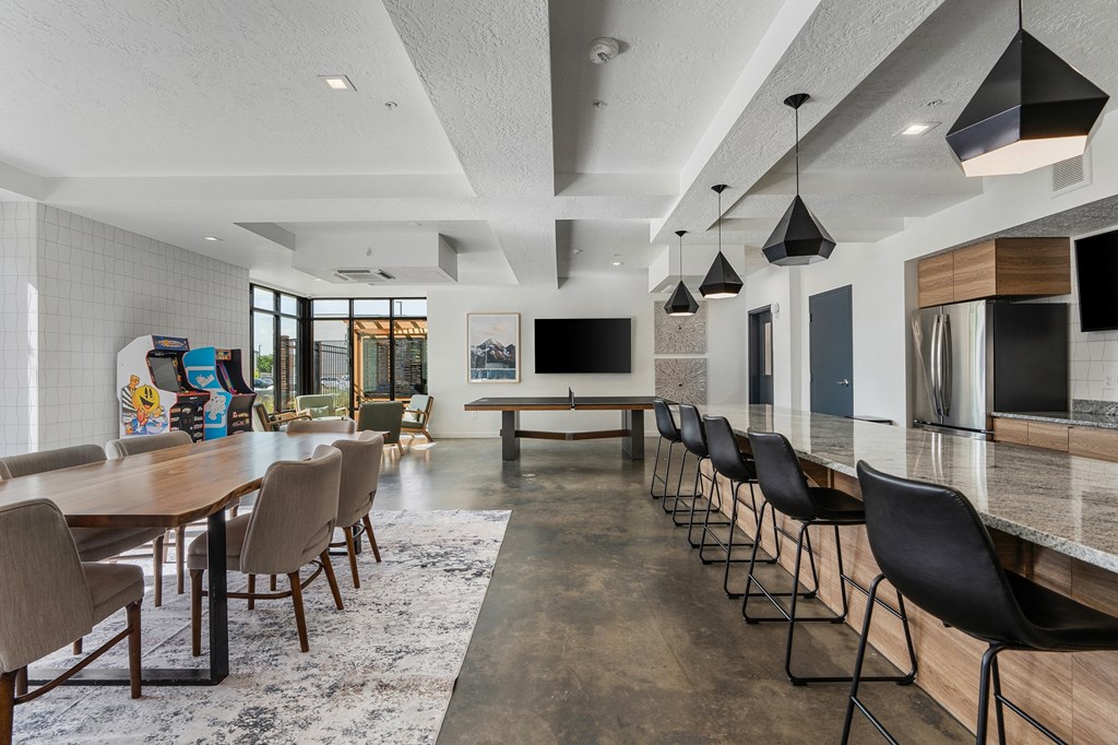 a large dining room with a long table and chairs and a kitchen and living room at The Flats at Riverwoods, Provo, UT, 84604
