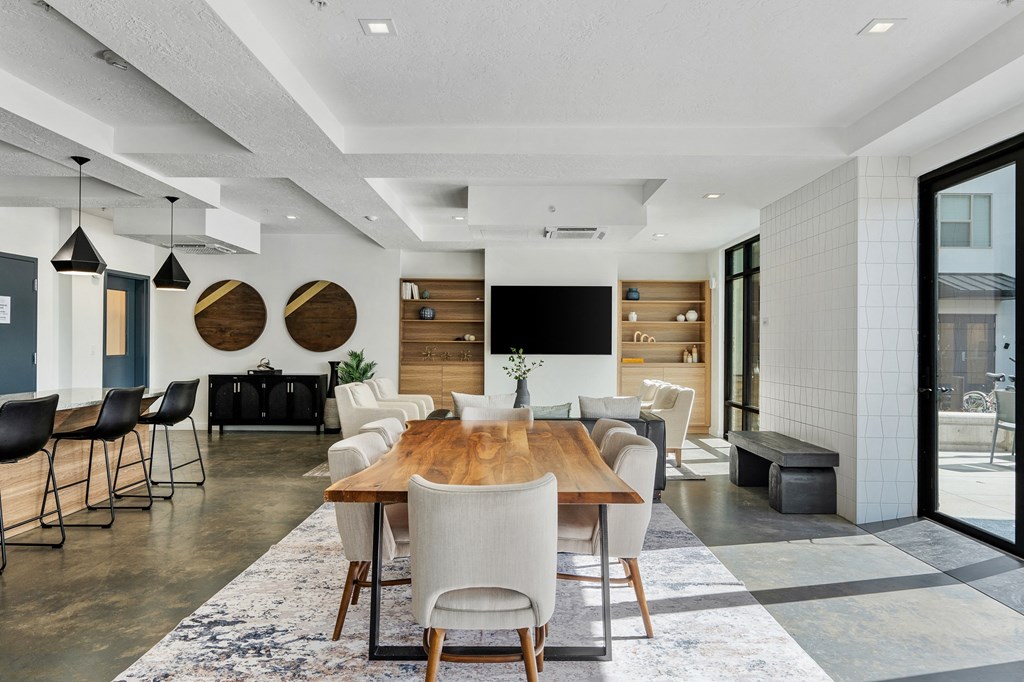 a dining room and living room with a wooden table and chairs at The Flats at Riverwoods, Provo, 84604
