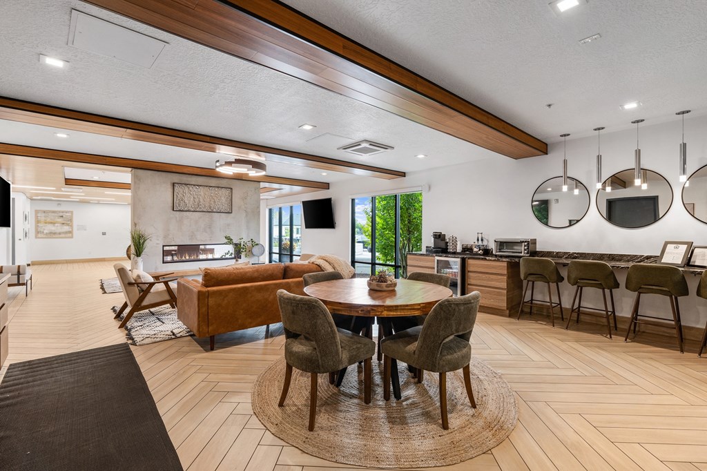 a living room with a table and chairs and a kitchen at The Flats at Riverwoods, Provo