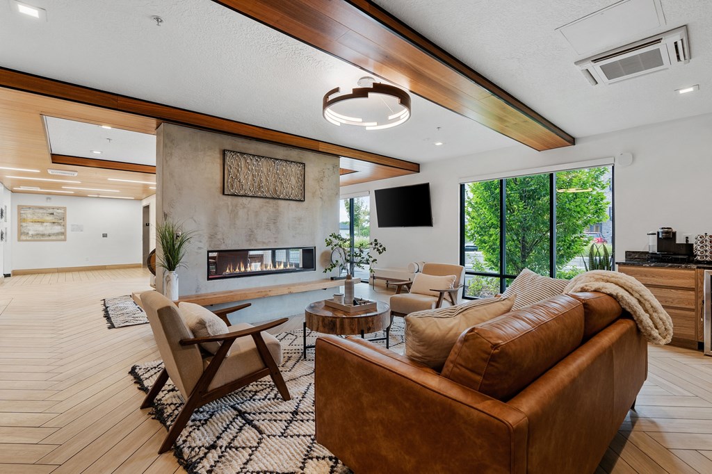 a living room with a couch and chairs and a fireplace at The Flats at Riverwoods, Provo, UT