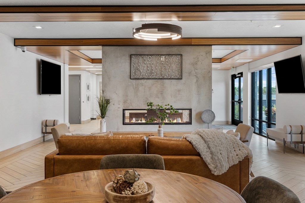 a living room with a couch and a table and a fireplace at The Flats at Riverwoods, Provo, UT, 84604