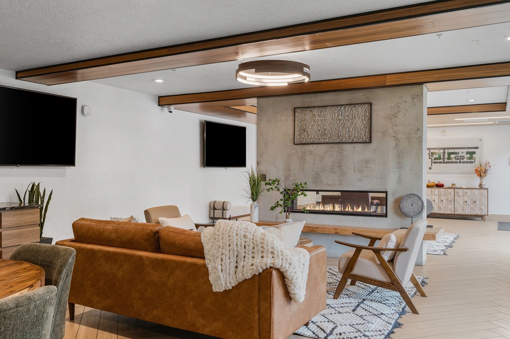 a living room with a couch and chairs and a fireplace at The Flats at Riverwoods, Provo, Utah