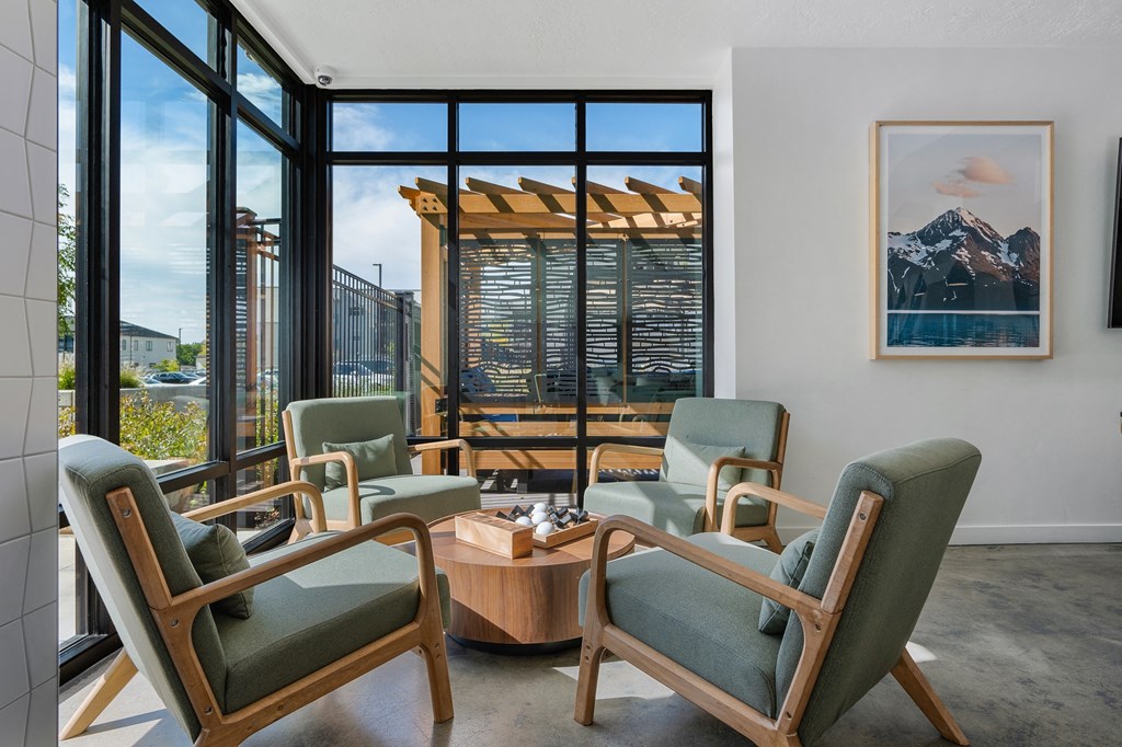 a living room with chairs and a coffee table and a view of a mountain at The Flats at Riverwoods, Provo