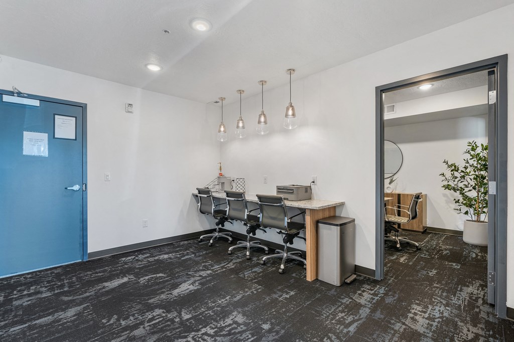 a conference room with a table and chairs and a blue door at The Flats at Riverwoods, Provo, 84604