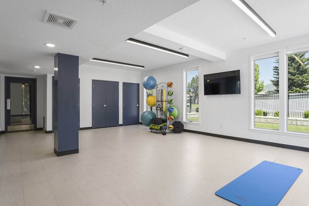 an empty room with a blue yoga mat and balloons at The Flats at Riverwoods, Provo, Utah