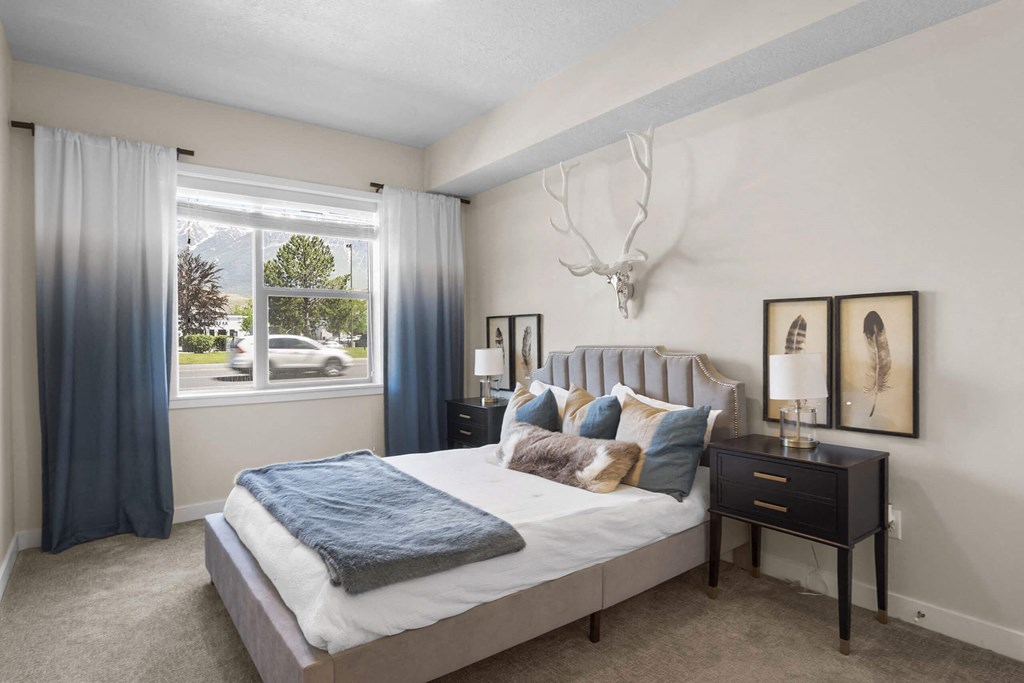 a bedroom with a large bed and a deer head on the wall at The Flats at Riverwoods, Utah, 84604
