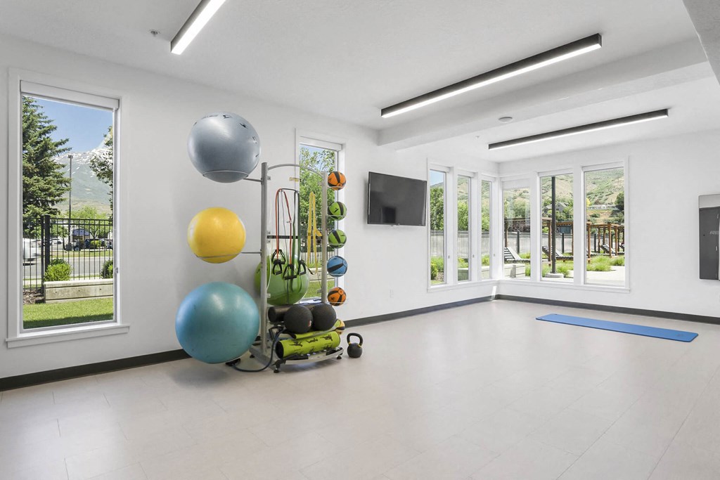 a large white room with white walls and white tile floors and a large window with a view at The Flats at Riverwoods, Provo, 84604