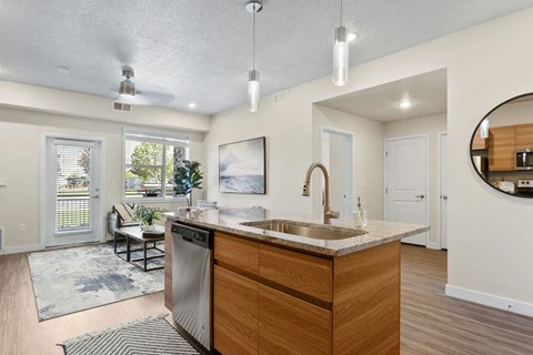 an open kitchen and living room with a large window and a sink