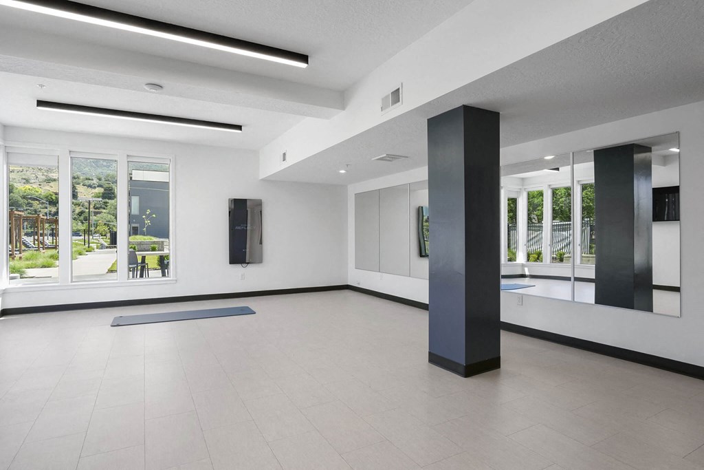 a large white room with a large window and a black pillar in the middle of the room at The Flats at Riverwoods, Provo, 84604
