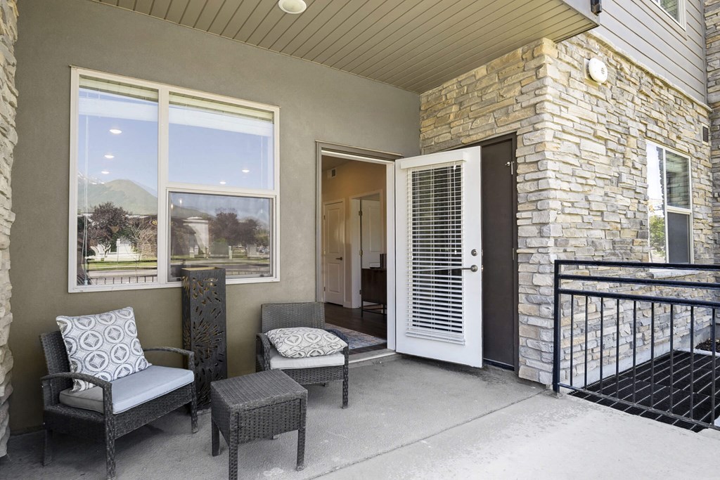 a balcony with two chairs and two doors with a view of the mountains at The Flats at Riverwoods, Utah, 84604