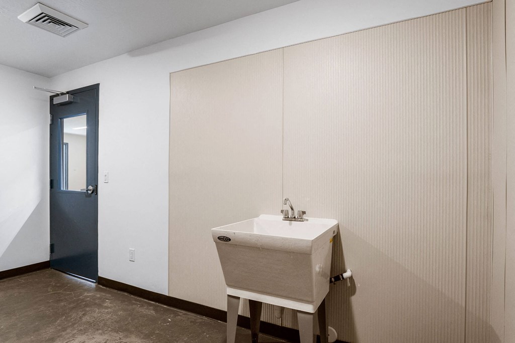 a sink in a bathroom with a blue door in the background at The Flats at Riverwoods, Provo, Utah