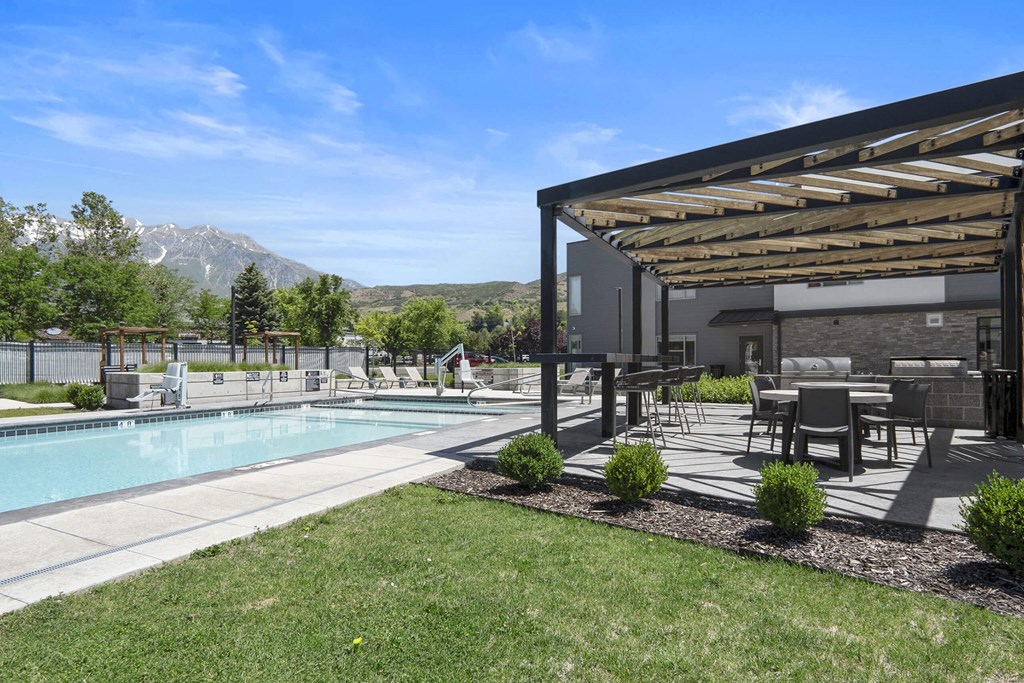 a backyard with a pool and patio with a pergola at The Flats at Riverwoods, Utah, 84604