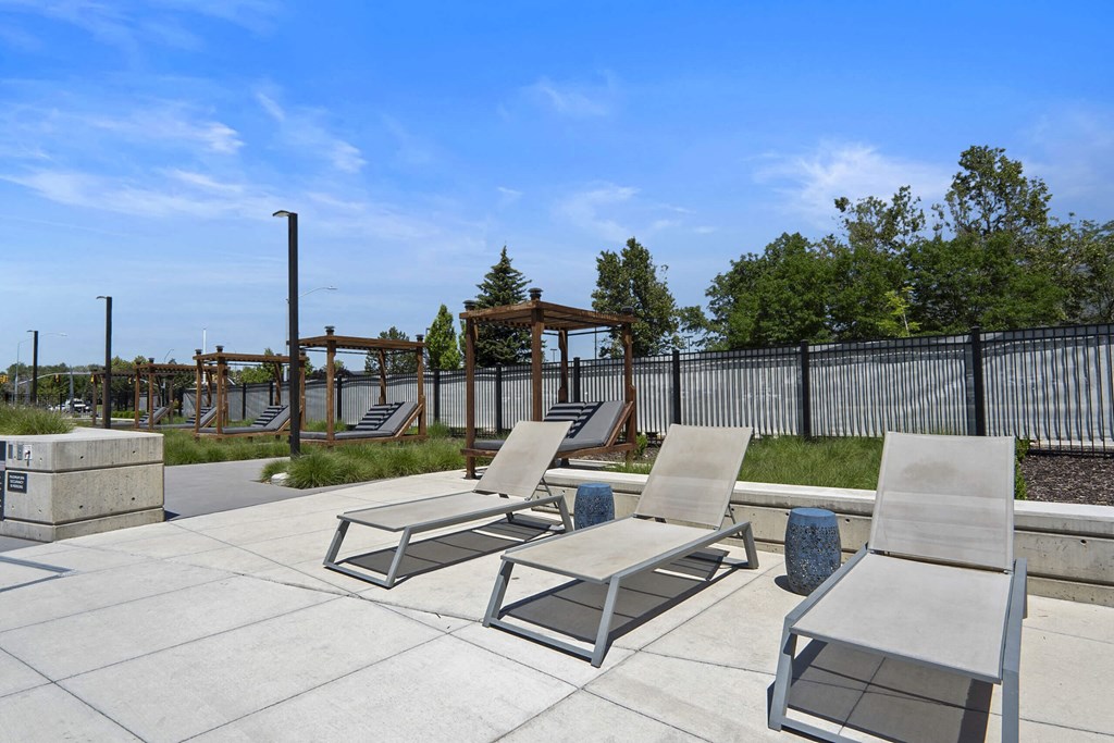 a patio with lounge chairs and a playground in the background at The Flats at Riverwoods, Utah, 84604