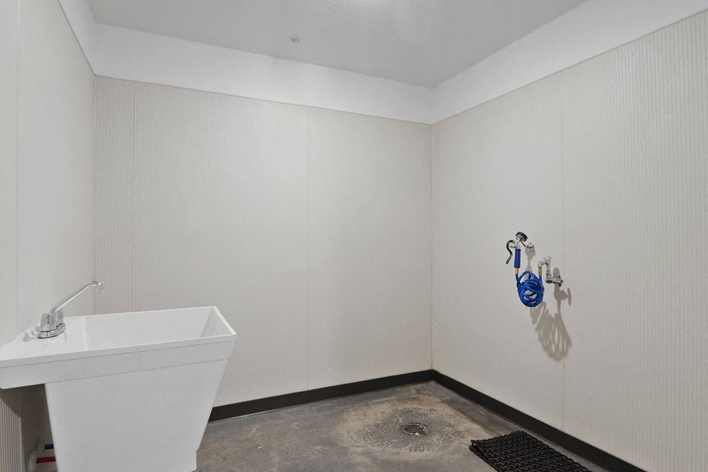 a bathroom with white walls and a white sink at The Flats at Riverwoods, Provo