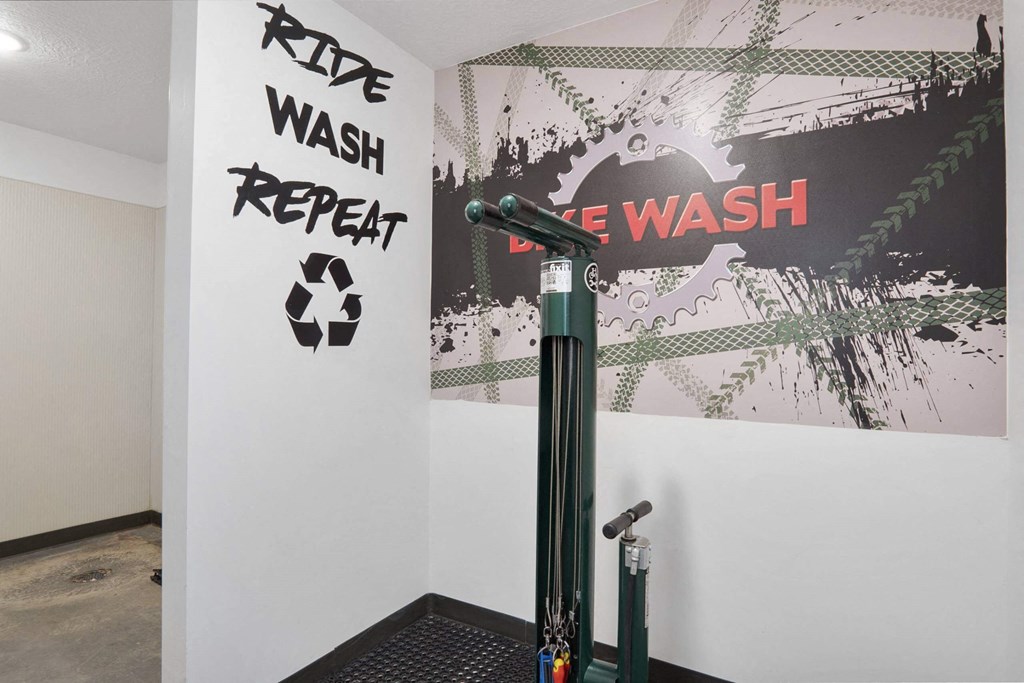 a room with a washing machine and a poster on the wall at The Flats at Riverwoods, Provo, Utah