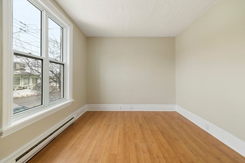 Empty room with wooden floor and white walls.