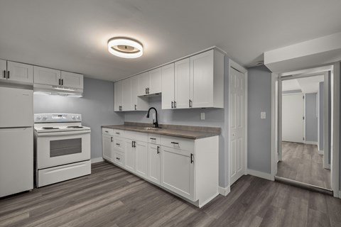 A kitchen with white appliances and cabinets.