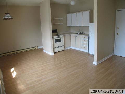 an empty kitchen and living room with wood floors