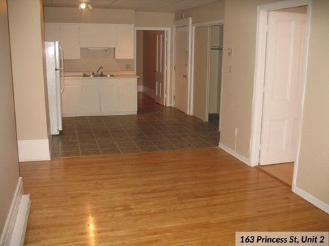 an open kitchen and living room with wood flooring