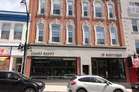 a city street with cars parked in front of a brick building