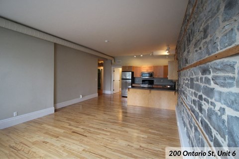 an open living room with a stone wall and wood floors