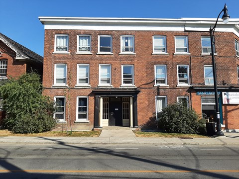 the front of a brick building with a black door