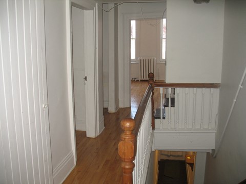 a view of the hallway from the top of the stairs looking into the living room