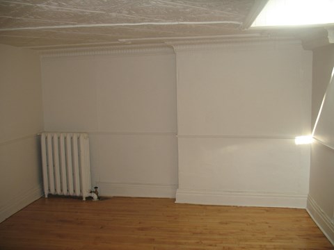 an empty room with white walls and a radiator