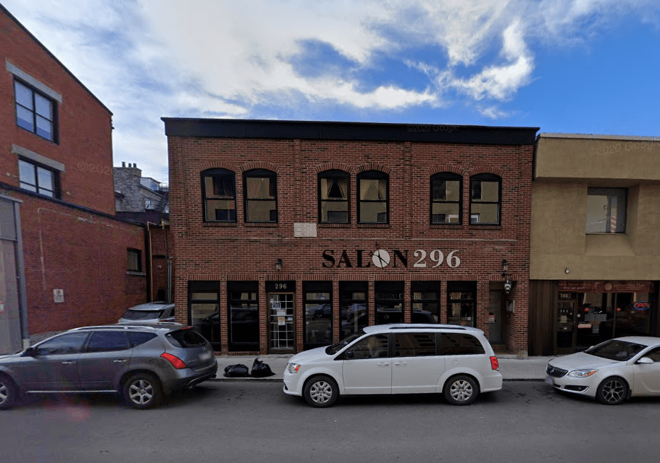 A white van is parked in front of a salon.