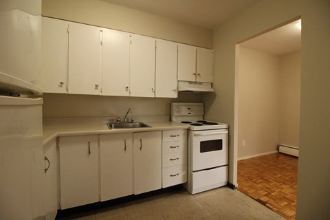 A kitchen with white cabinets and a sink.