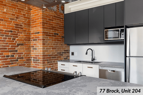 A kitchen with a brick wall and a sink.