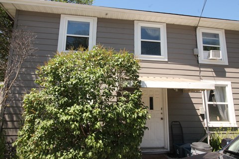 the exterior of a house with a white door and windows