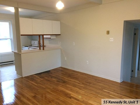 an empty living room with a hard wood floor